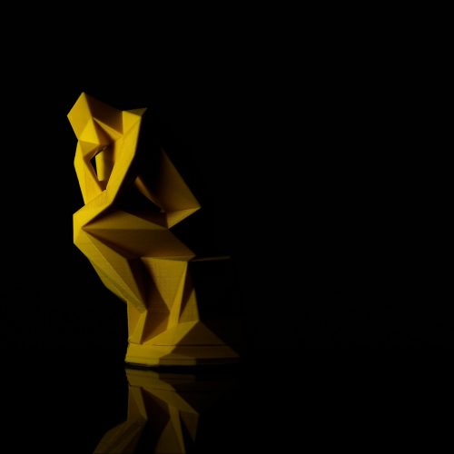 Yellow abstract sculpture based on Rodin's 'The Thinker'