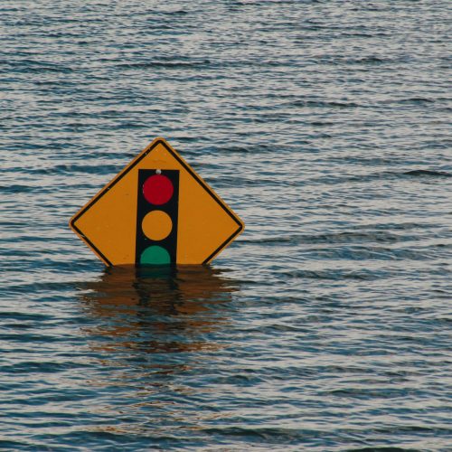 Flooding showing road sign mostly submerged